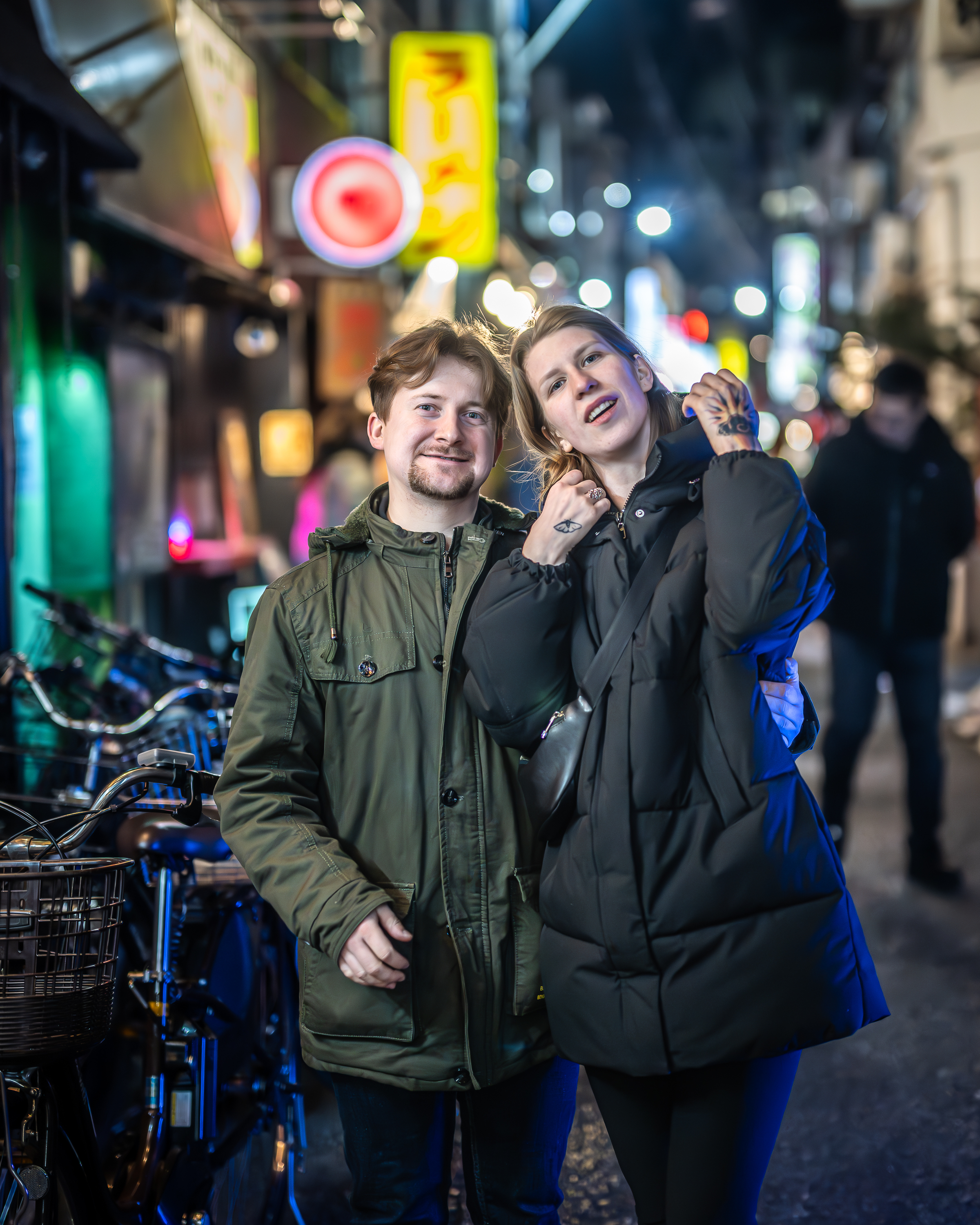 Couple on a neon-lit street at night
